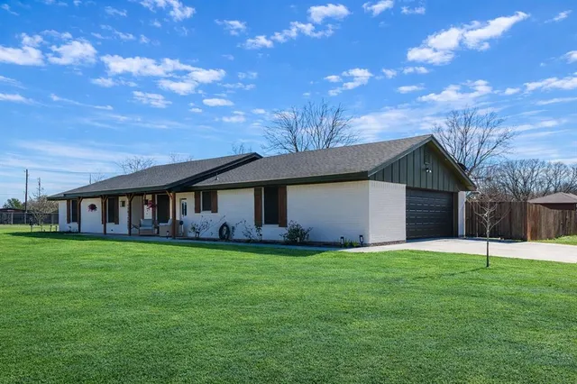 a view of a house with a yard and tree
