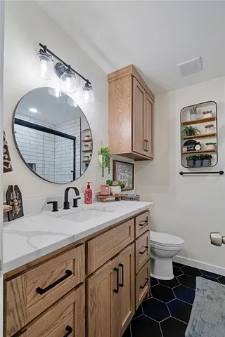 a bathroom with a sink a toilet and a mirror