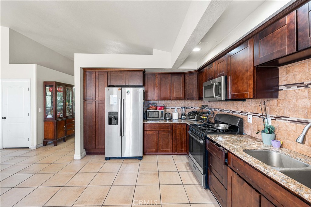 4331 Avoca Avenue Palmdale, CA 93552 - Photo 8 of 17 a kitchen with stainless steel appliances granite countertop a refrigerator stove and sink