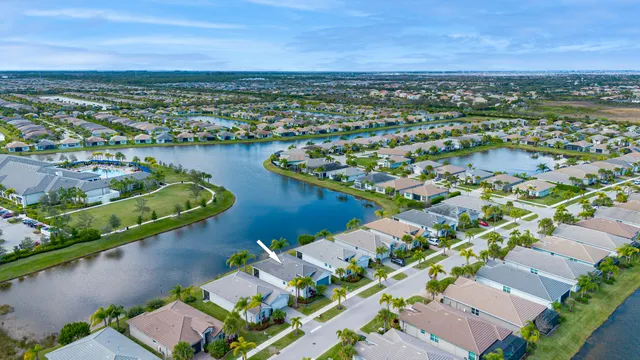a large white kitchen with stainless steel appliances granite countertop a stove and a wooden floors