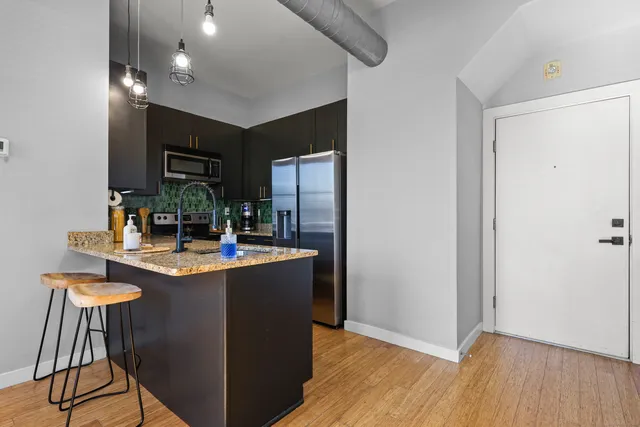 a kitchen with kitchen island stainless steel appliances a sink stove and refrigerator