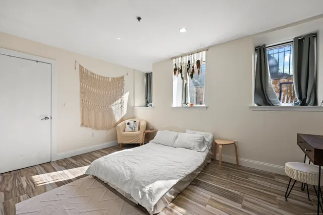 a bedroom with a bed and wooden floor