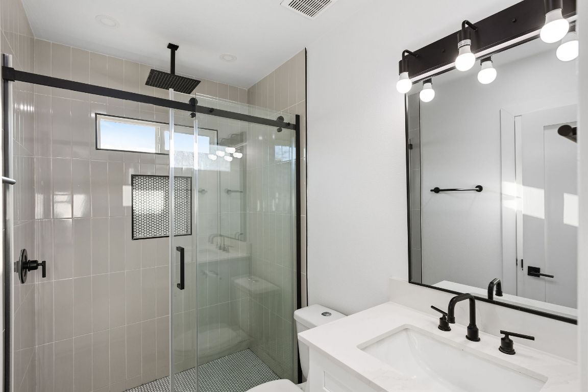 3004 Webberville Road, Unit 1 Austin, TX 78702 - Photo 11 of 12 a bathroom with a sink shower and a mirror
