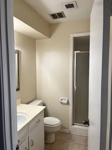 a bathroom with a granite countertop toilet and a sink