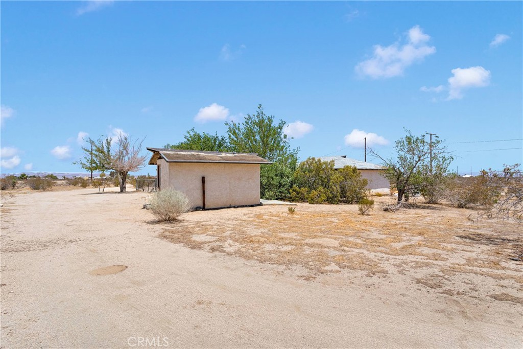 5335 Palmdale Road Phelan, CA 92371 - Photo 26 of 37 a large house with a yard and trees in the background