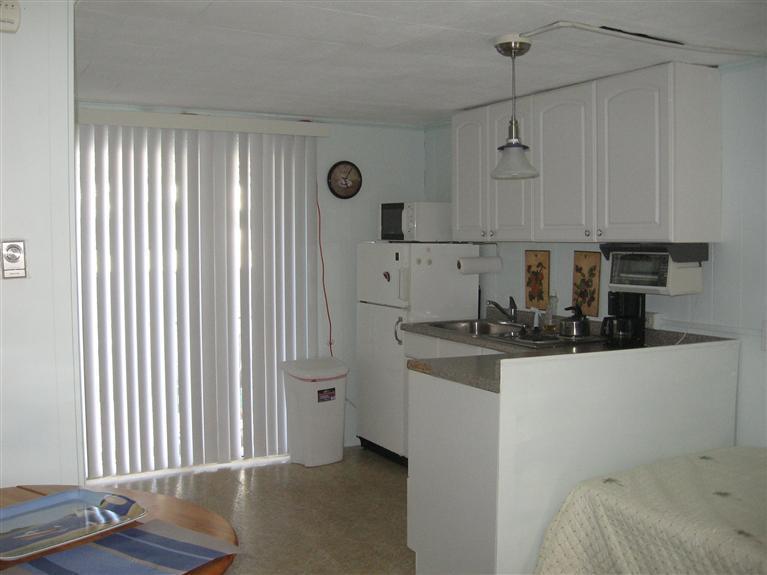 126 Lower County Road, Unit 6 Dennis Port, MA 02639 - Photo 3 of 12 a kitchen with stainless steel appliances granite countertop a sink a stove and a refrigerator