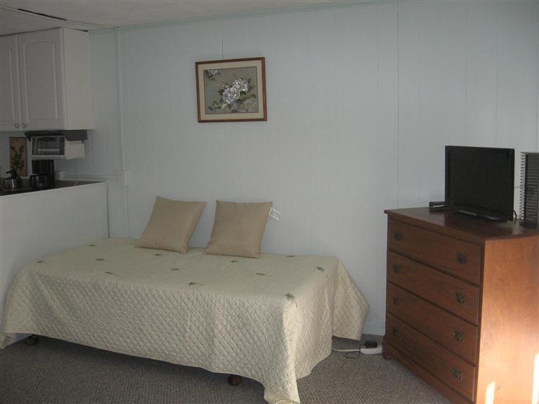 126 Lower County Road, Unit 6 Dennis Port, MA 02639 - Photo 6 of 12 a bedroom with a bed and a flat tv screen on a dresser
