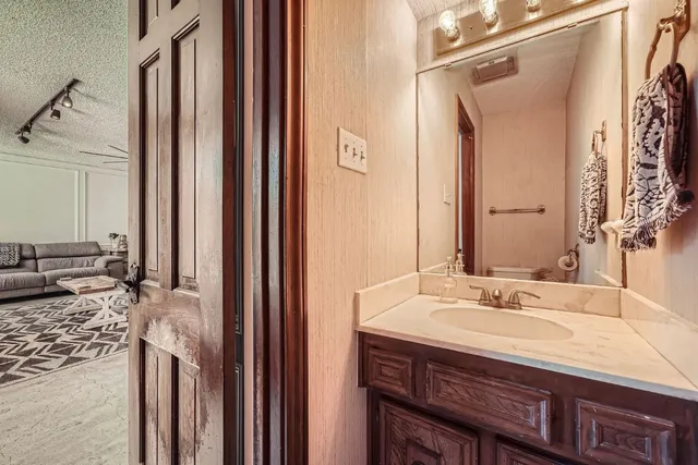 a bathroom with a granite countertop sink and a mirror
