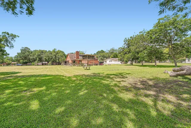 a view of a green field with trees in the background