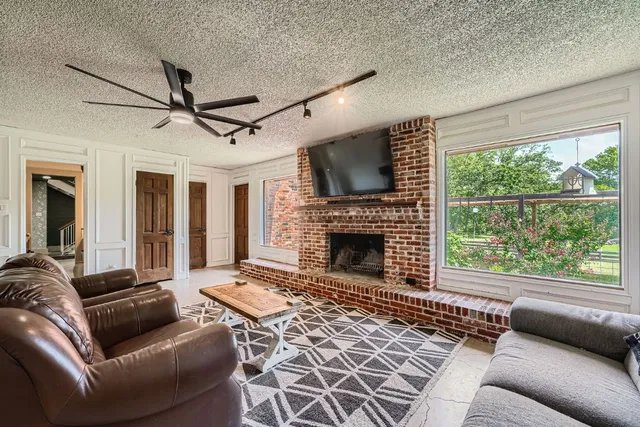 a living room with furniture a flat screen tv and a fireplace