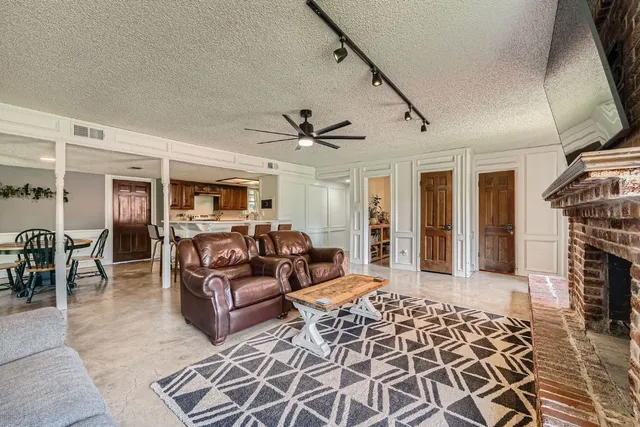 a living room with furniture a fireplace and a flat screen tv