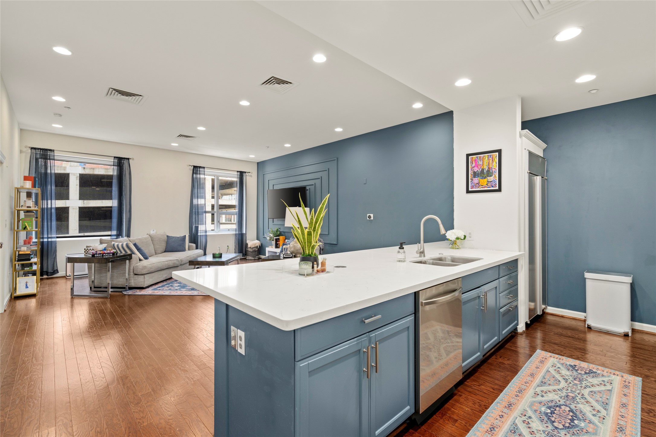 914 Main Street, Unit 1008 Houston, TX 77002 - Photo 2 of 26 Quartz countertops on a spacious island with updated cabinetry and recessed lighting for a clean, modern look.