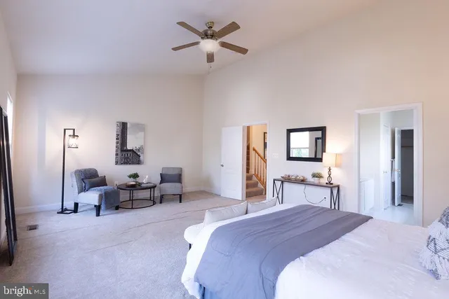 a bedroom with bed a table and chair