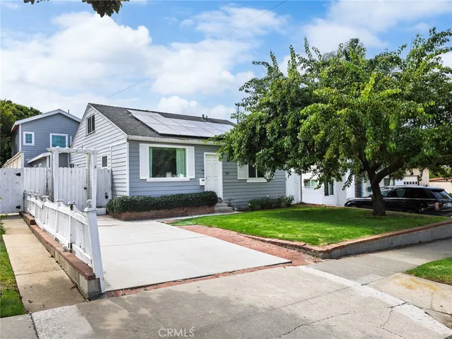 a front view of a house with a yard and trees