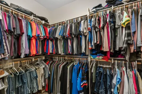 a view of walk in closet with clothes