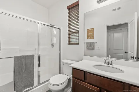 a bathroom with a granite countertop sink toilet and shower