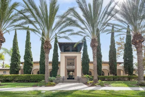 a front view of a house with garden and trees