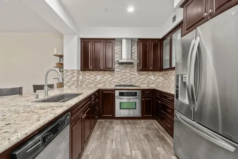 a kitchen with granite countertop a refrigerator stove and sink