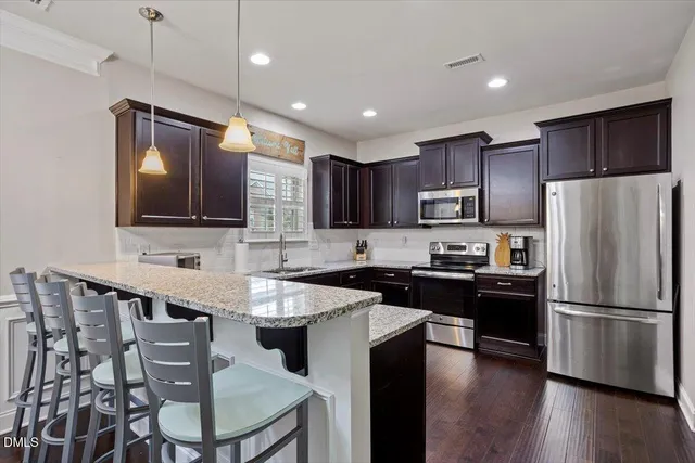 a view of a dining room with furniture a kitchen and chandelier