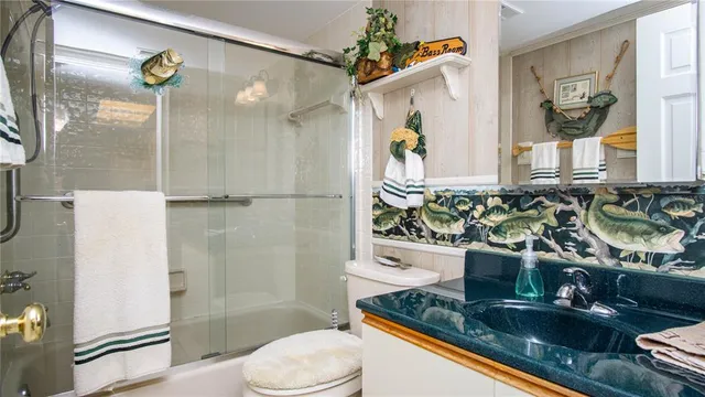 a bathroom with a granite countertop sink a toilet and shower