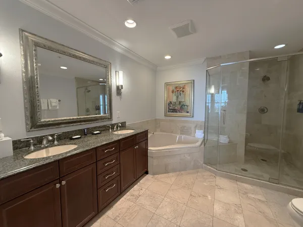 a spacious bathroom with a tub sink shower and mirror