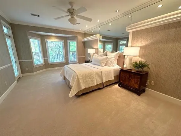 a spacious bedroom with a bed and large windows