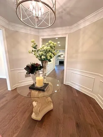 a vase of flowers sitting on a table with a chandelier