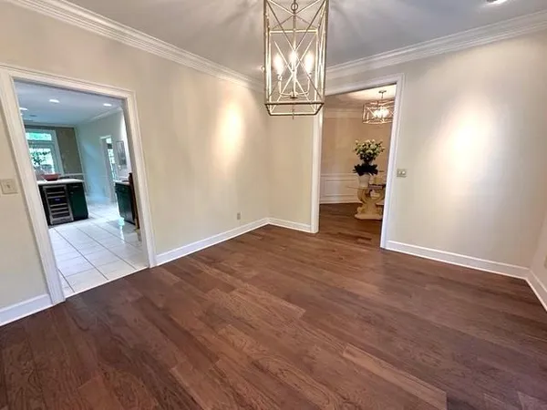 wooden floor in an empty room with a chandelier