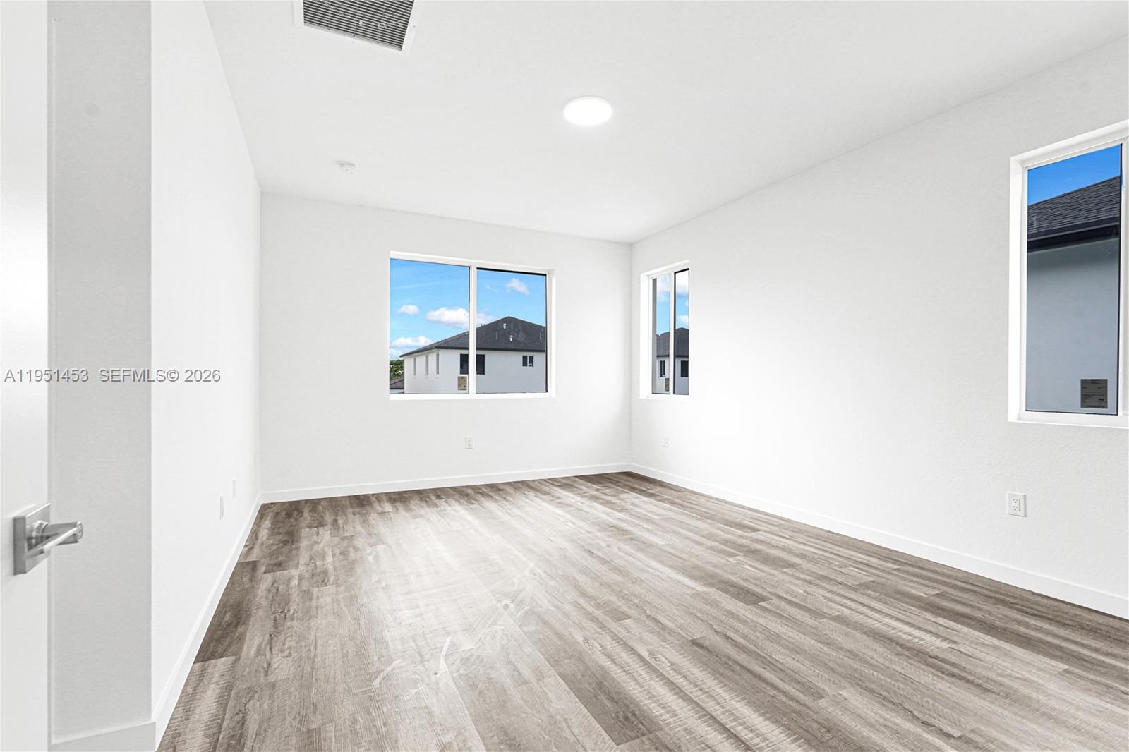 22431 Southwest 125th Avenue, Unit 19B Homestead, FL 33033 - Photo 31 of 40 an empty room with wooden floor and windows