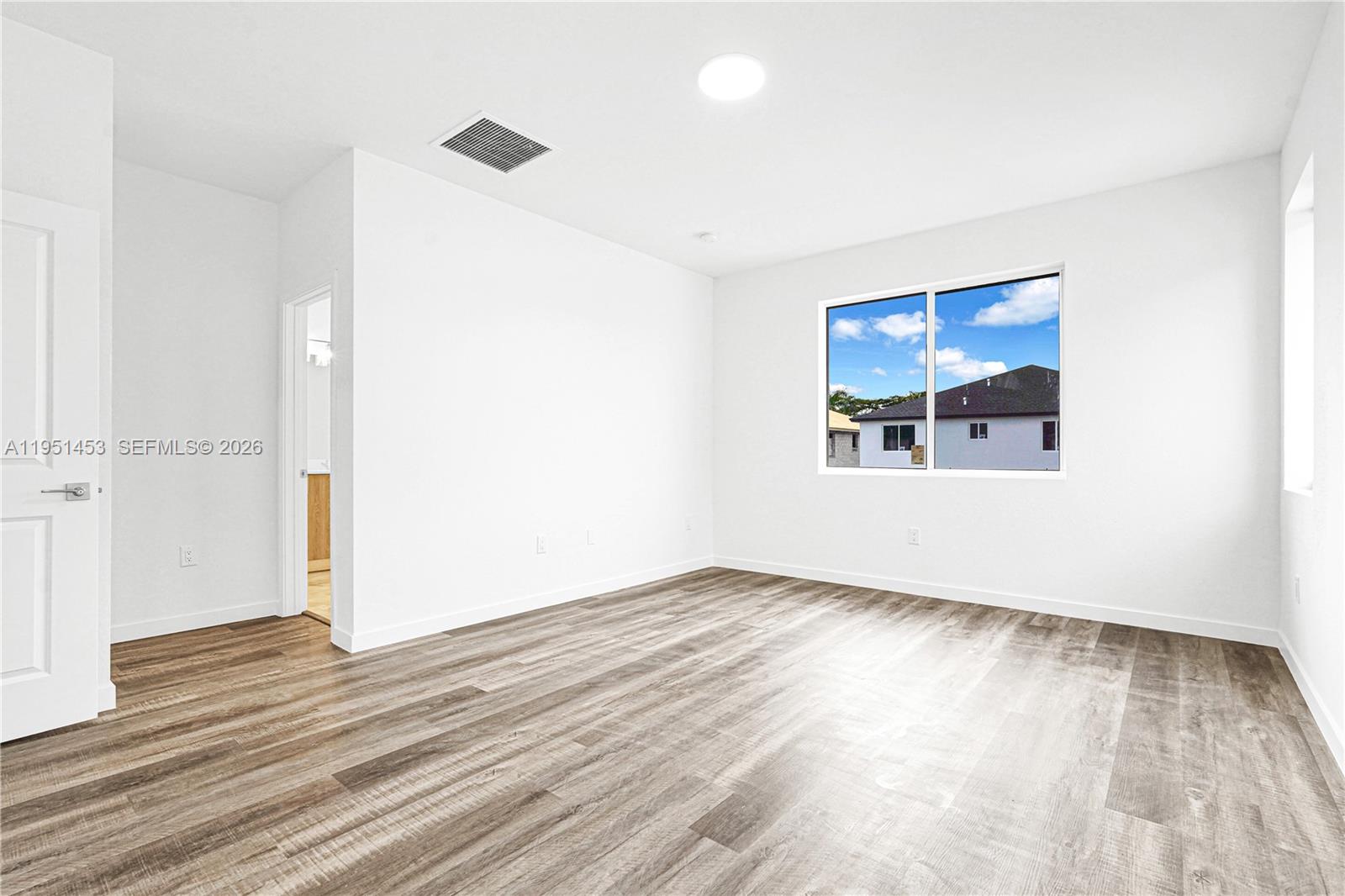 22431 Southwest 125th Avenue, Unit 19B Homestead, FL 33033 - Photo 32 of 40 an empty room with wooden floor and windows