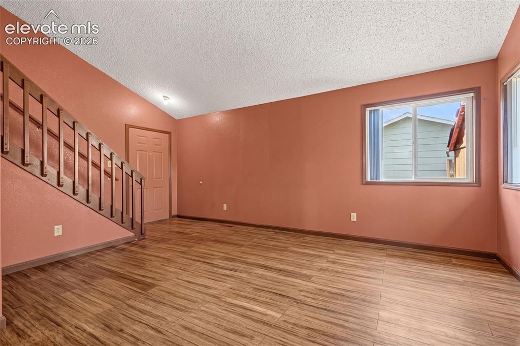 613 Wheat Field Road Fountain, CO 80817 - Photo 4 of 32 a view of an empty room with wooden floor and stairs