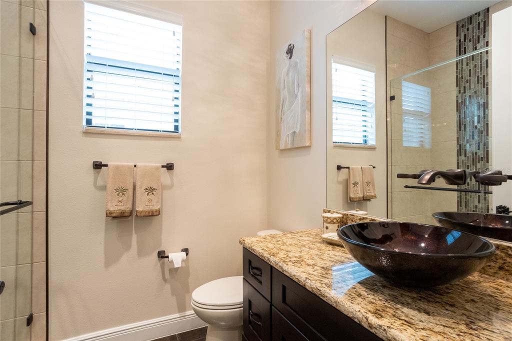 105 Wimbledon Court Redington Shores, FL 33708 - Photo 38 of 64 a bathroom with a granite countertop sink a toilet and a mirror