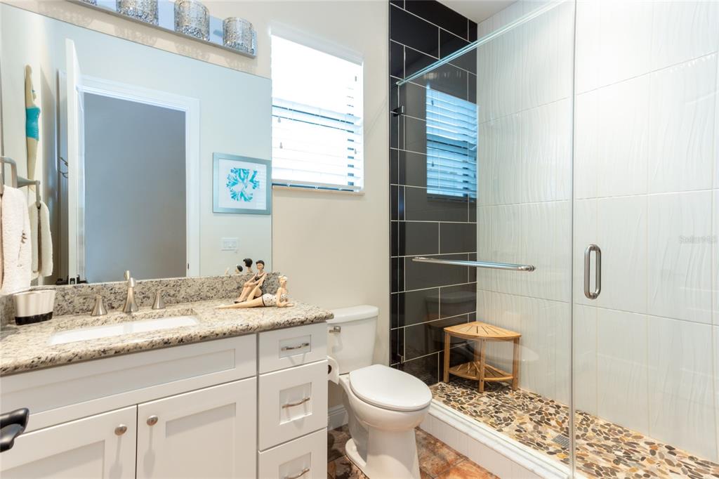 105 Wimbledon Court Redington Shores, FL 33708 - Photo 43 of 64 a bathroom with a granite countertop toilet sink and mirror