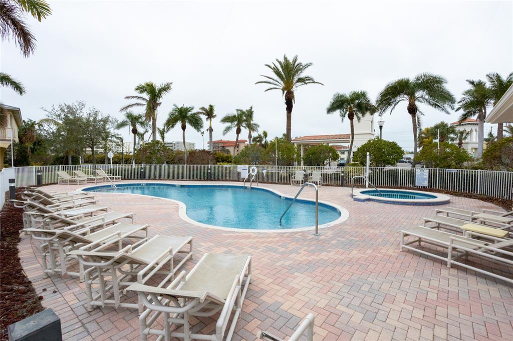 105 Wimbledon Court Redington Shores, FL 33708 - Photo 61 of 64 a view of a swimming pool with a lawn chairs and palm tree