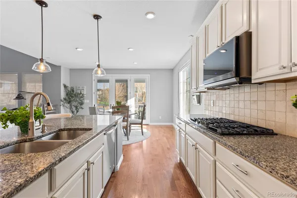 a kitchen with granite countertop a sink a counter space cabinets and stainless steel appliances