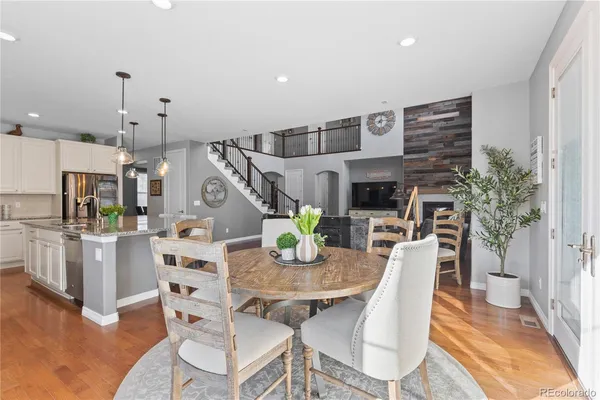 a view of a dining room with furniture a rug and wooden floor
