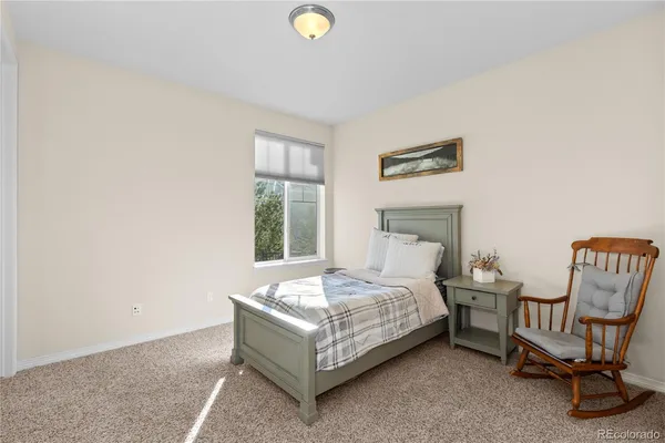 a bedroom with a bed chair and window