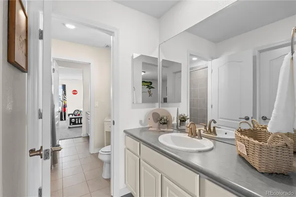a bathroom with a granite countertop sink a toilet and a mirror