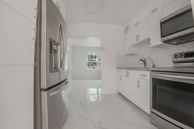 a kitchen with stainless steel appliances granite countertop a refrigerator and a stove top oven