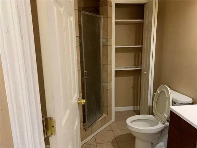 an empty room with a ceiling fan and wooden floor