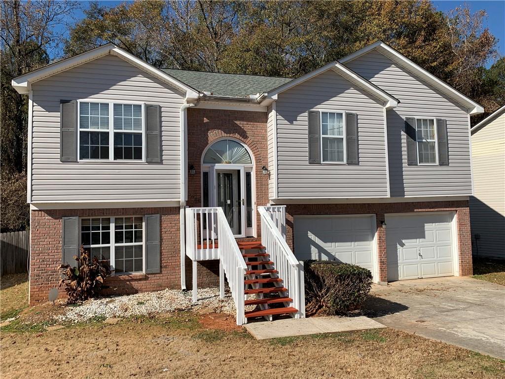 2195 Clayton Ridge Lithonia, GA 30058 - Photo 23 of 23 a front view of a house with a yard and garage