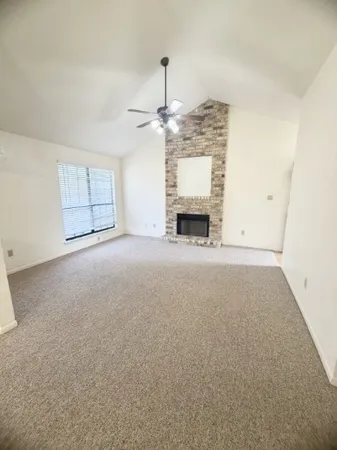 an empty room with fireplace and windows