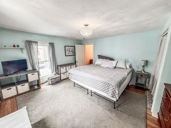 a spacious bedroom with a bed and a flat screen tv