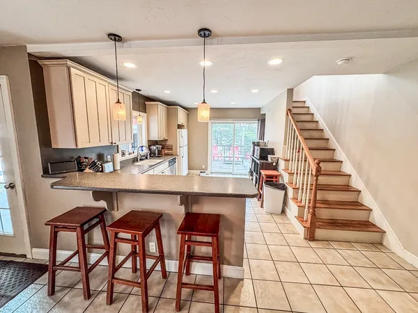 a kitchen with stainless steel appliances kitchen island granite countertop a stove a sink and a refrigerator