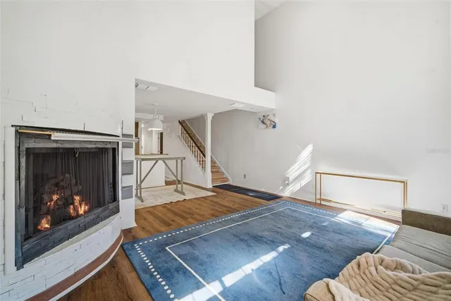 a kitchen with stainless steel appliances kitchen island granite countertop a refrigerator a stove a microwave oven with white cabinets and wooden floor