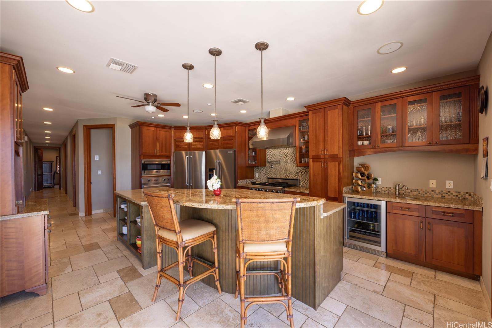 365 Portlock Road Honolulu, HI 96825 - Photo 10 of 25 a kitchen with stainless steel appliances granite countertop a stove top oven a sink a dining table and chairs