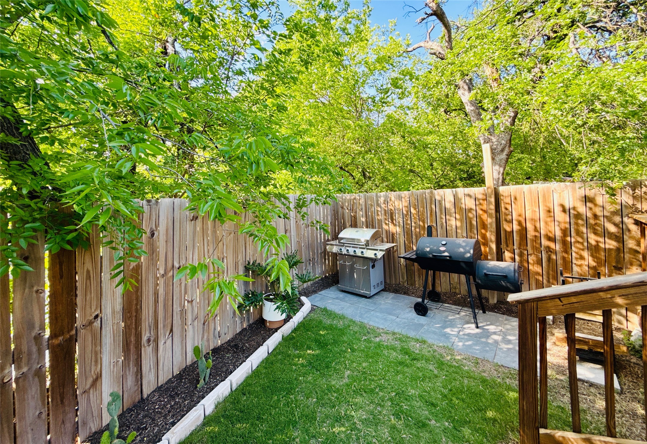 1616 Webberville Road, Unit A Austin, TX 78721 - Photo 31 of 35 The property features a fenced yard with a well-maintained lawn and a paved patio area