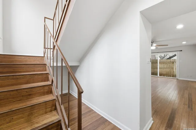 a view of staircase with wooden floor and a rug