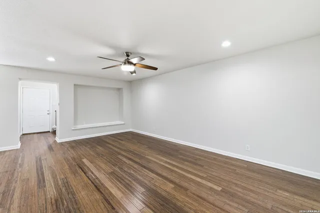 a view of an empty room with wooden floor