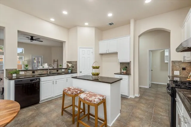 a kitchen with granite countertop kitchen island cabinets and refrigerator